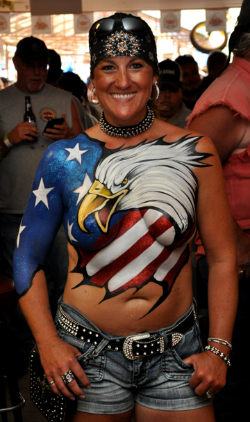body painted woman with a united states flag themed log on her chest that features a bald eagle head
